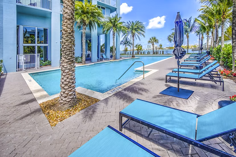 Stunning bayfront pool at Navette on the Bay Apartments with luxury seating and panoramic water views