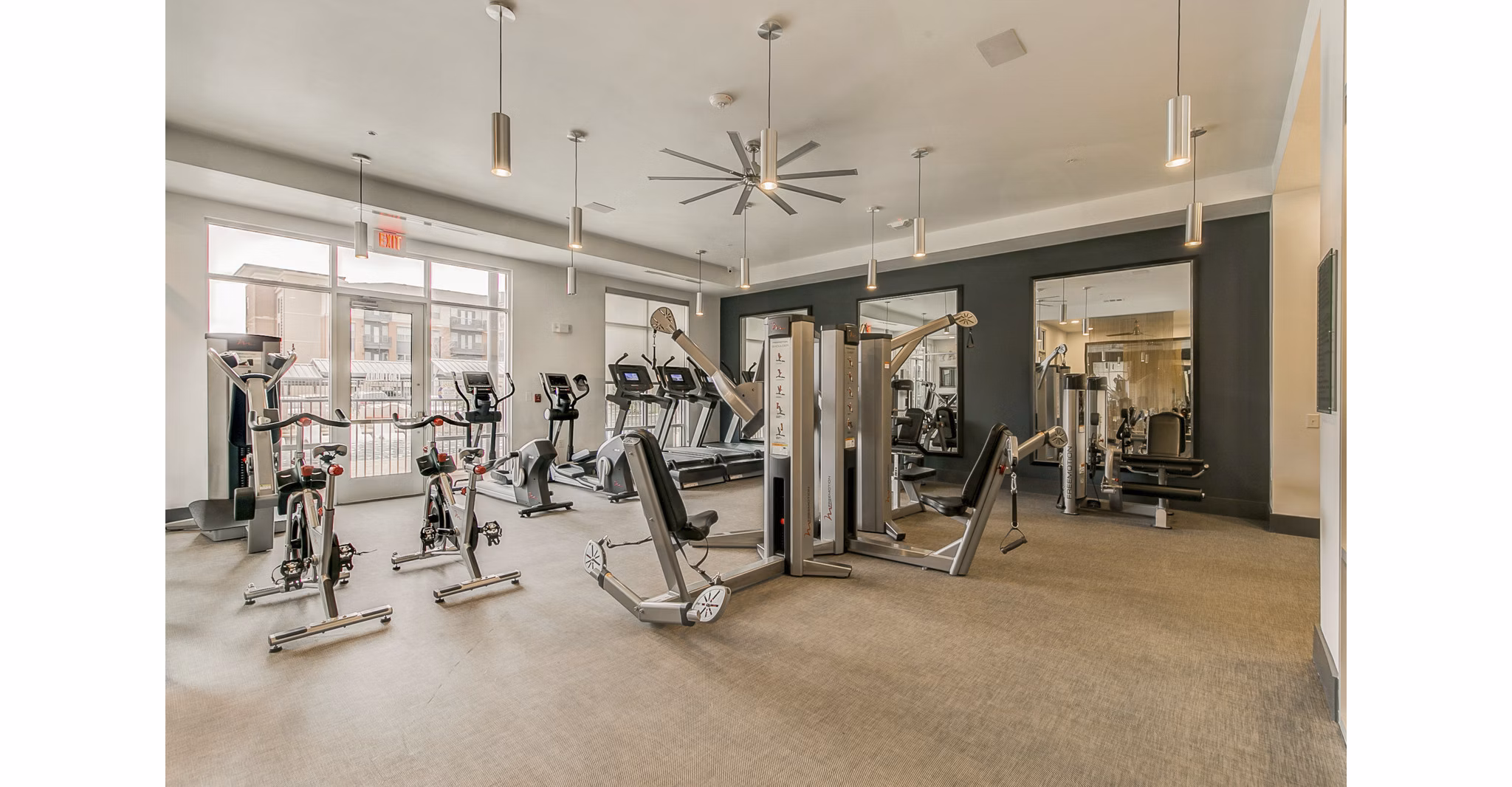 Modern fitness center equipped with cardio machines and free weights at Eastbank Riverwalk Apartments