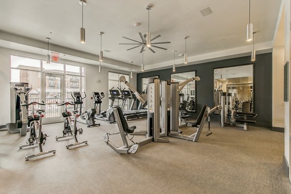 Modern fitness center equipped with cardio machines and free weights at Eastbank Riverwalk Apartments