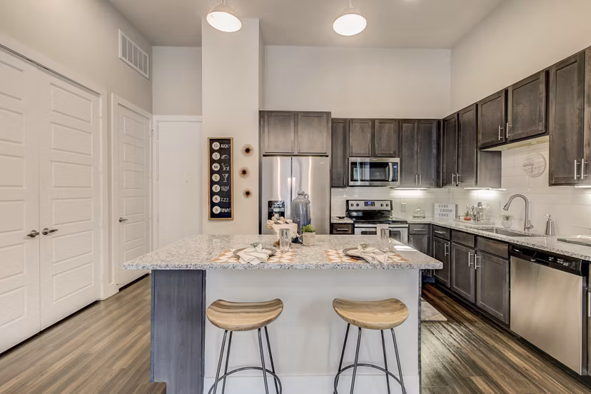 Modern kitchen with stainless steel appliances and granite countertops at Eastbank Riverwalk Apartments