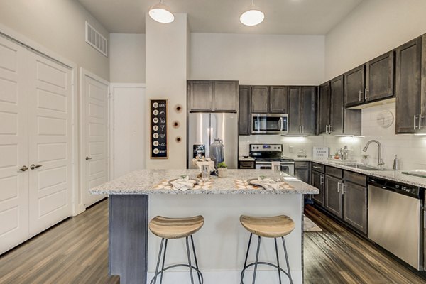 Modern kitchen with stainless steel appliances and granite countertops at Eastbank Riverwalk Apartments