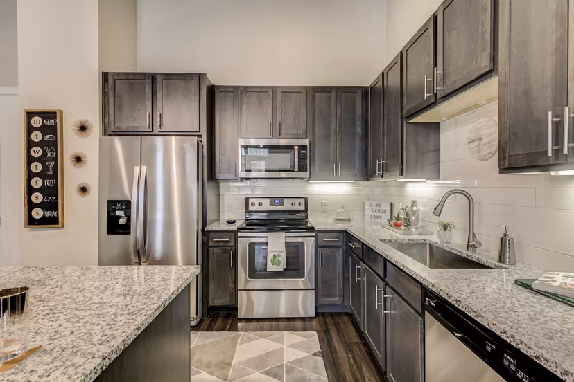 Contemporary kitchen design with stainless steel appliances at Eastbank Riverwalk Apartments