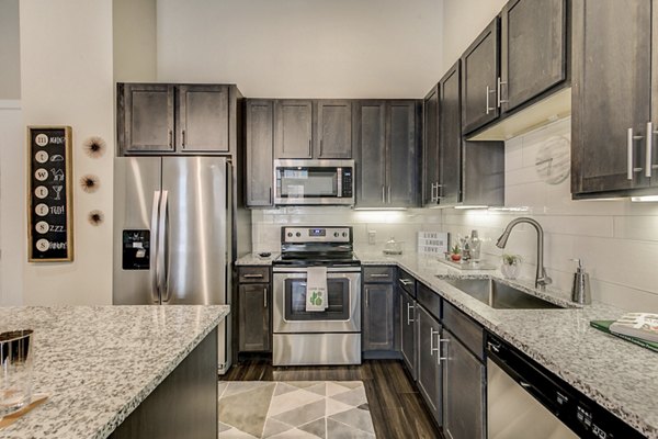 Contemporary kitchen design with stainless steel appliances at Eastbank Riverwalk Apartments