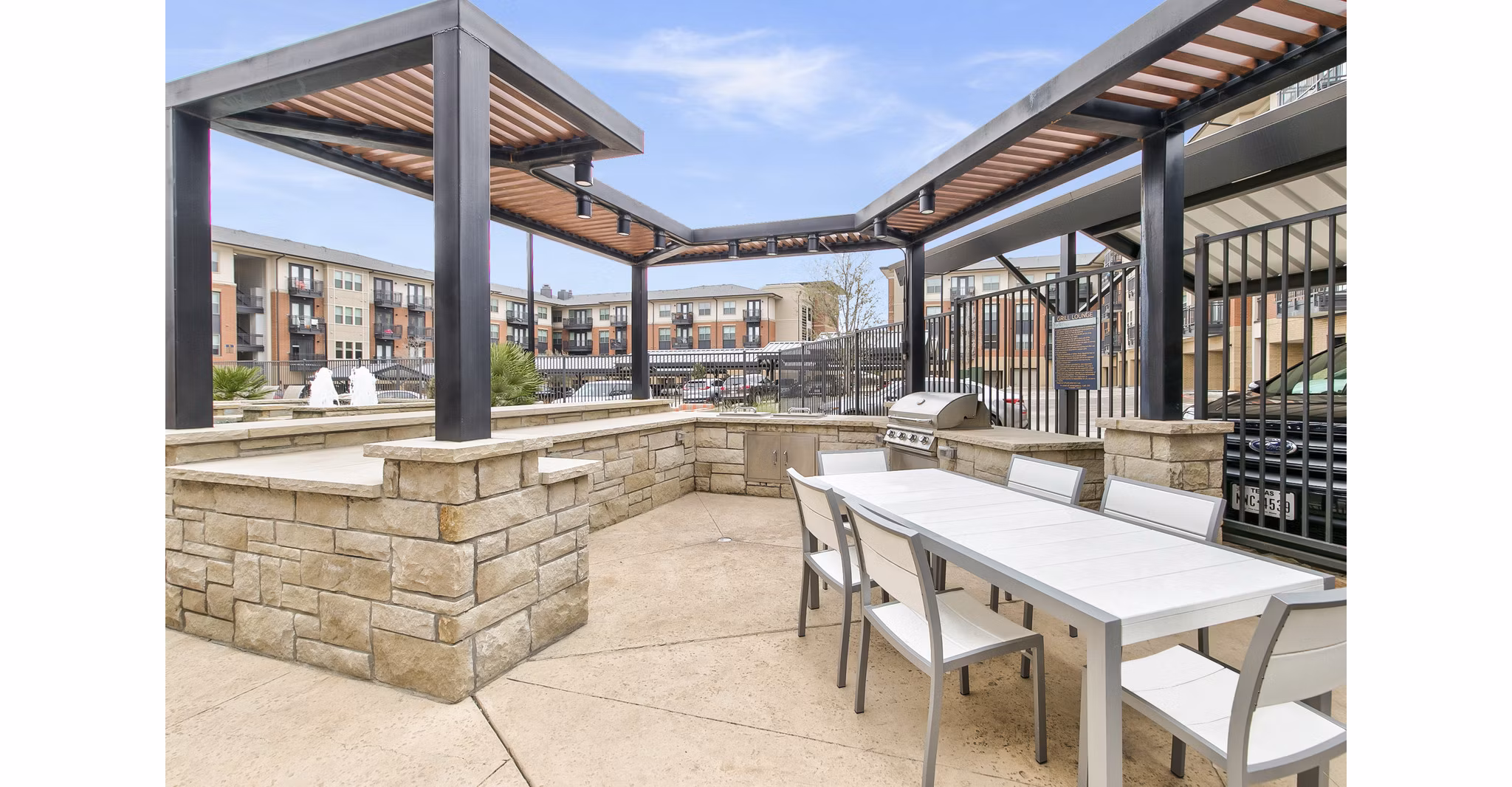 Outdoor grill area with stylish seating at Eastbank Riverwalk Apartments, offering a relaxing place for residents to gather and enjoy meals
