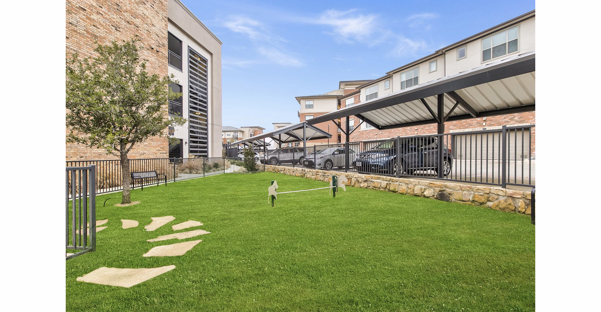 Fenced dog park with play area at Eastbank Riverwalk Apartments, offering a pet-friendly outdoor space for luxury living