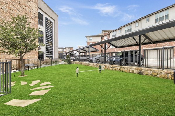 Fenced dog park with play area at Eastbank Riverwalk Apartments, offering a pet-friendly outdoor space for luxury living
