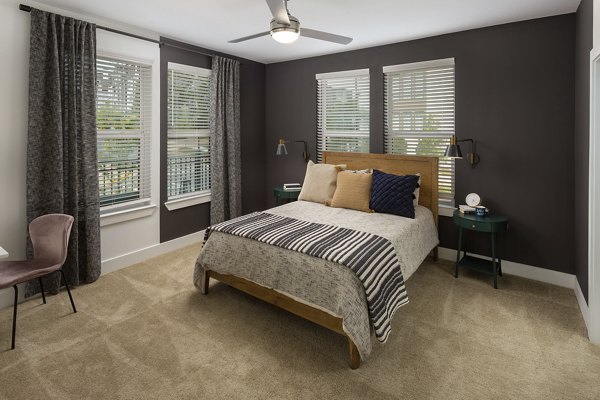 Bedroom featuring modern decor and large windows at Elan Madison Yards Apartments
