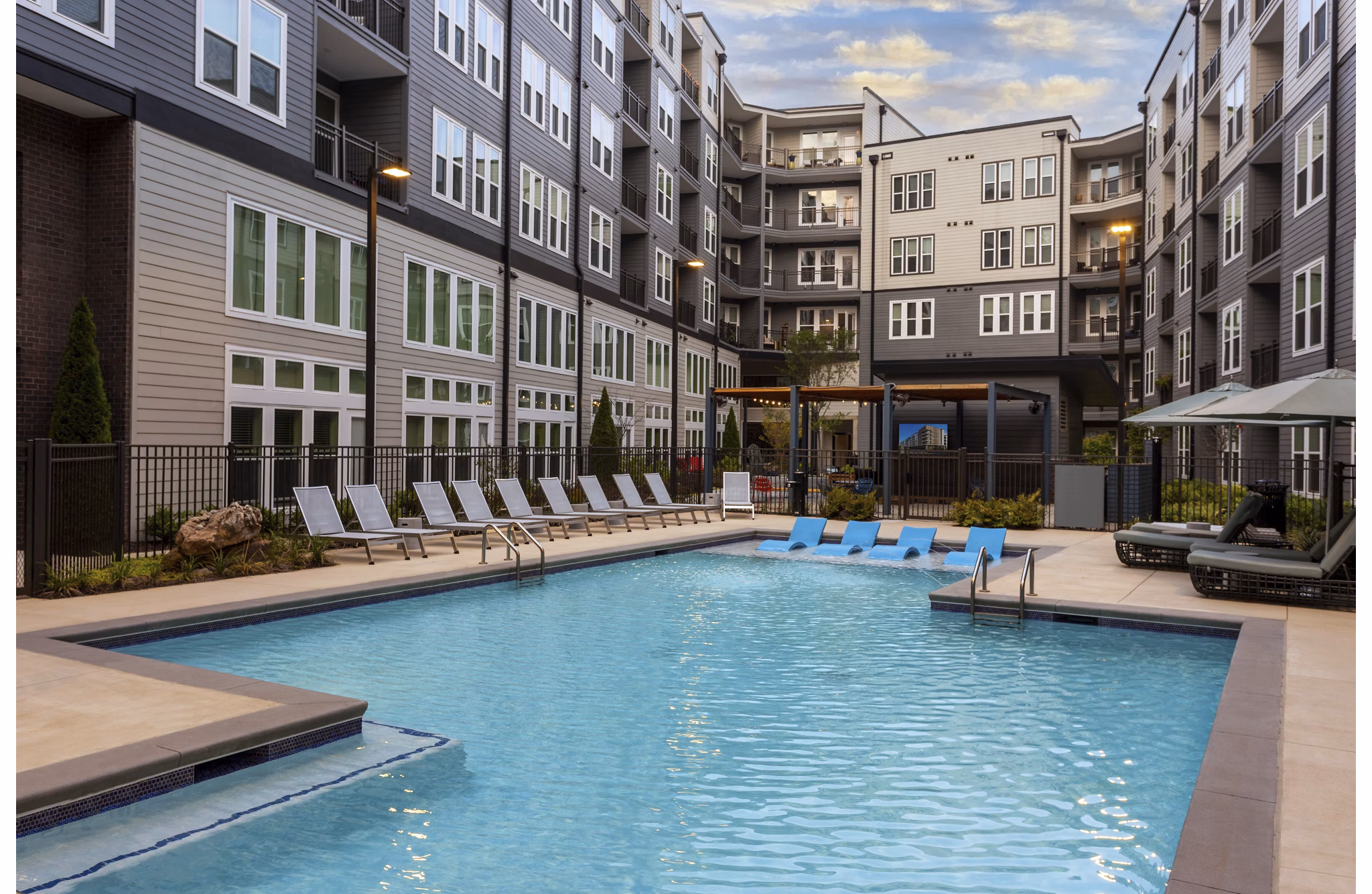 Resort-style pool at Elan Madison Yards Apartments with lounging areas and lush landscaping