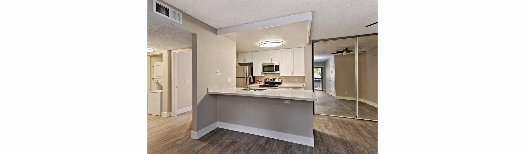 Modern kitchen with granite countertops and stainless appliances in Presidio at Rancho Del Oro Apartments
