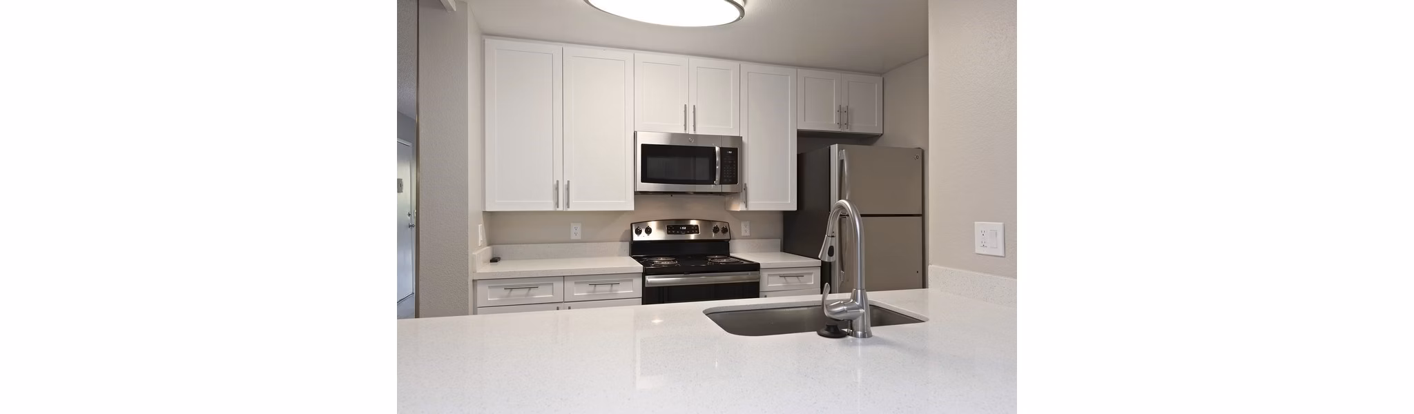 Modern kitchen with stainless steel appliances at Presidio at Rancho Del Oro Apartments