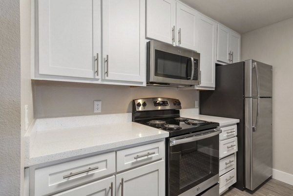 Modern kitchen featuring stainless steel appliances at Presidio at Rancho Del Oro Apartments