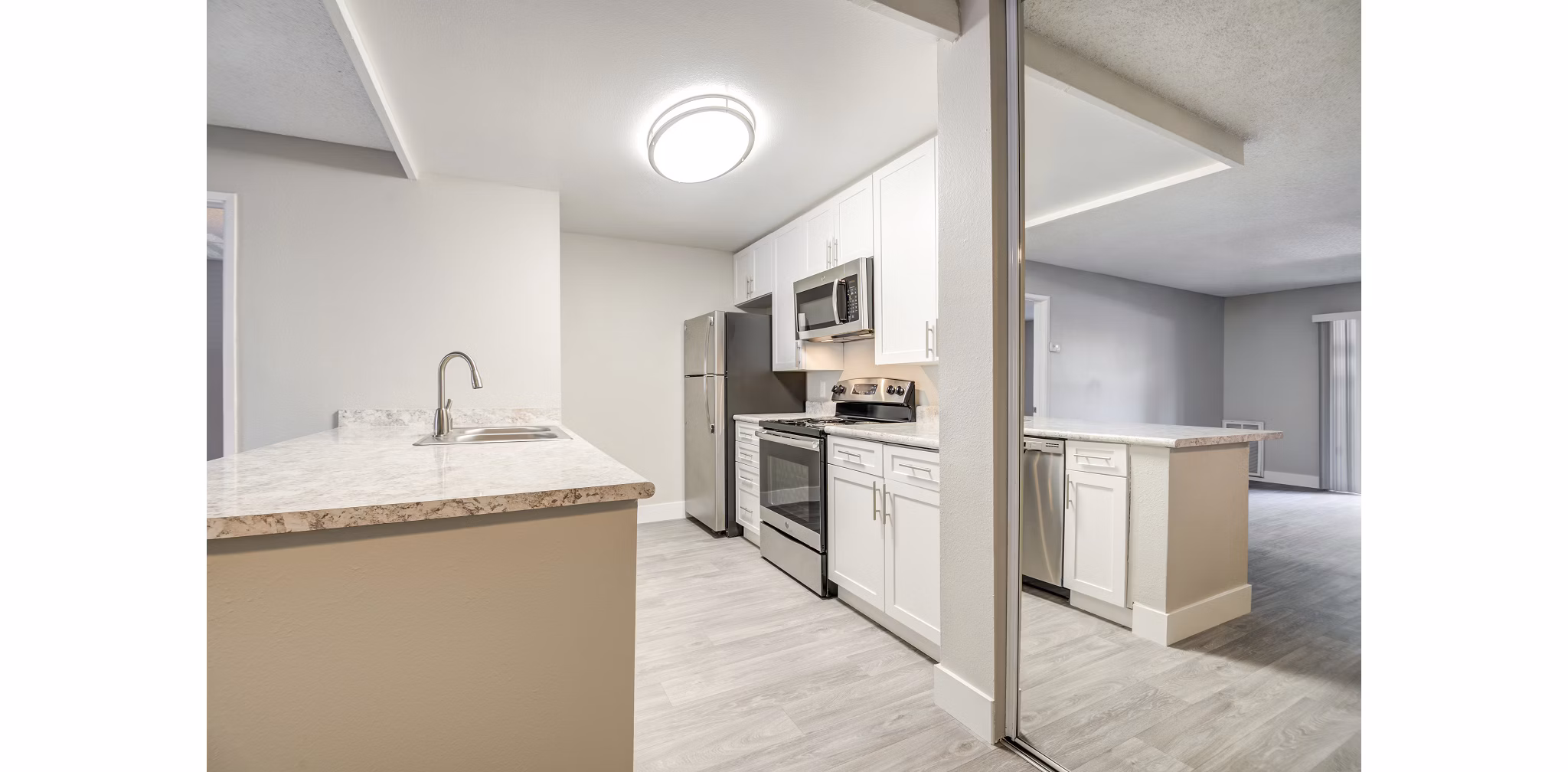 Modern kitchen with stainless steel appliances in Presidio at Rancho Del Oro Apartments