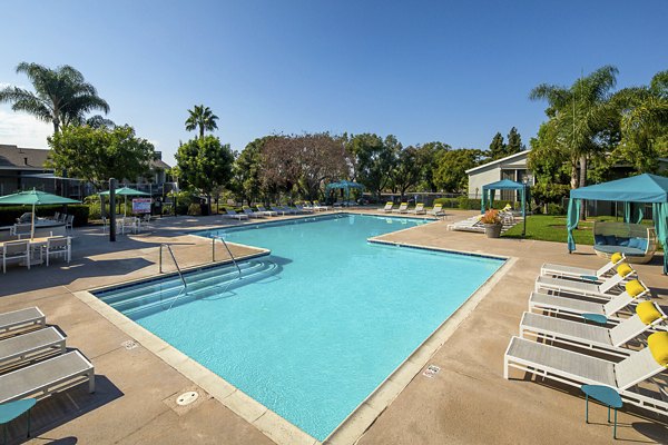 Expansive pool area with lounge seating at Presidio at Rancho Del Oro Apartments