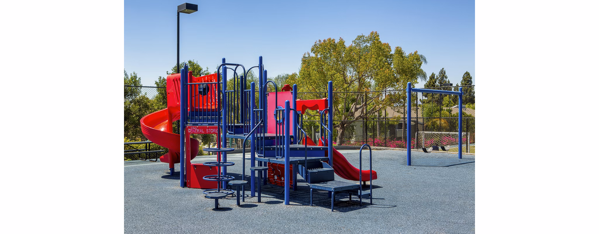 Playground area with slides and swings at Presidio at Rancho Del Oro Apartments, a family-friendly amenity for residents