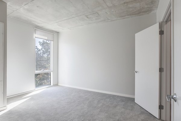 Modern bedroom with cozy ambiance and elegant decor in The Chestnut Apartments, a luxury Greystar property