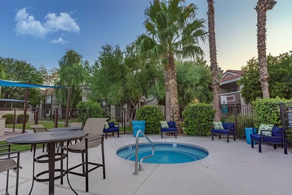 Resort-style pool surrounded by palm trees at Springs at Continental Ranch Apartments