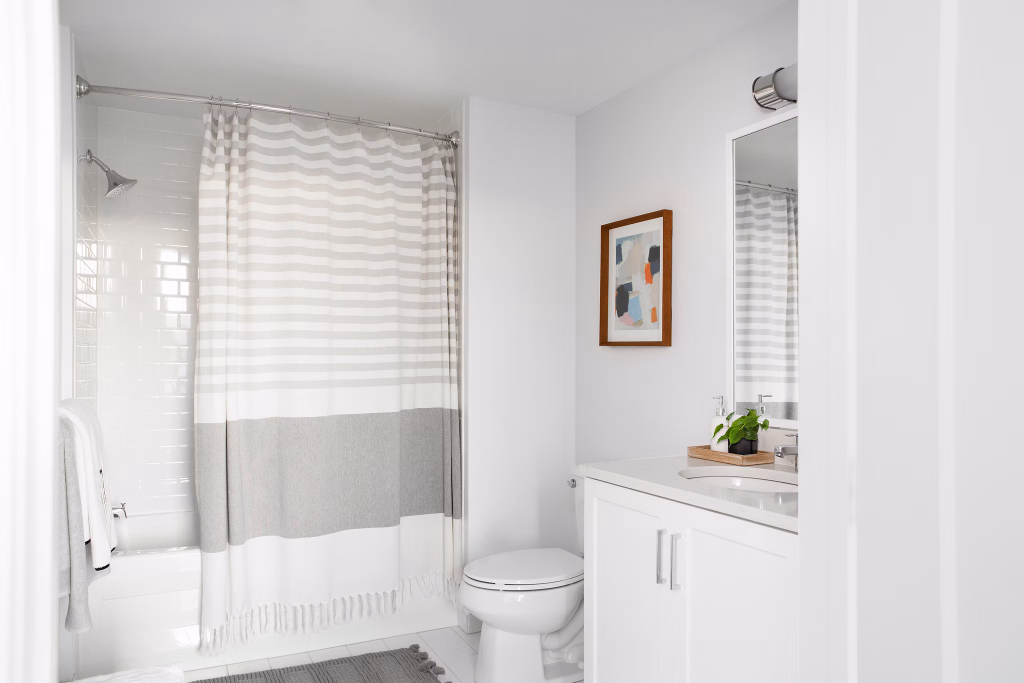 Modern bathroom with a shower, sink, and decorative wall art in luxury apartments