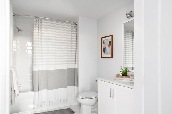 Modern bathroom with a shower, sink, and decorative wall art in luxury apartments