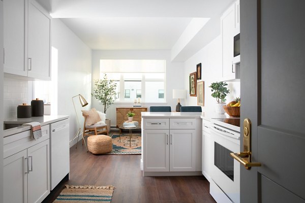Modern kitchen with sleek countertops and stainless steel appliances at The Madelon Apartments