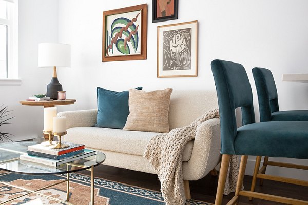 Spacious living room with modern decor and large windows at The Madelon Apartments