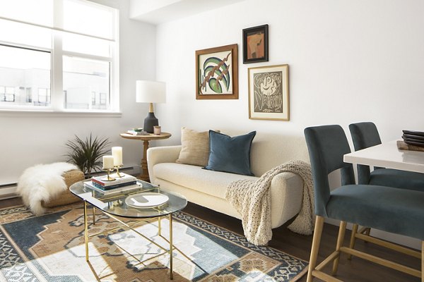 Spacious living room with modern decor and natural light at The Madelon Apartments