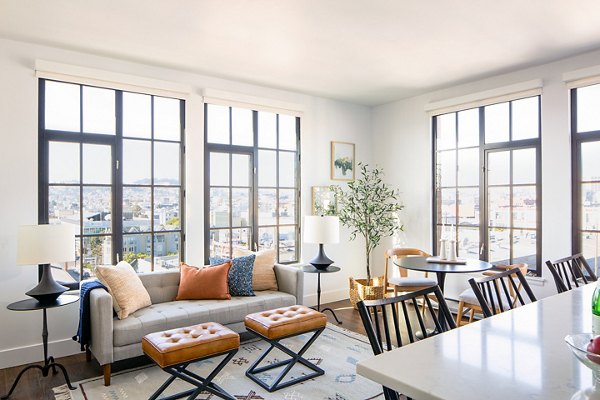 Spacious living room with modern furnishings and large windows at The Madelon Apartments, a Greystar luxury property