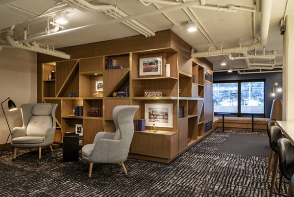 Cozy reading nook with bookshelves and armchairs in luxury apartments