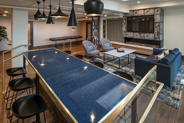 Modern living room with a long dining table, cozy seating area, large TV, and fireplace in luxury apartment