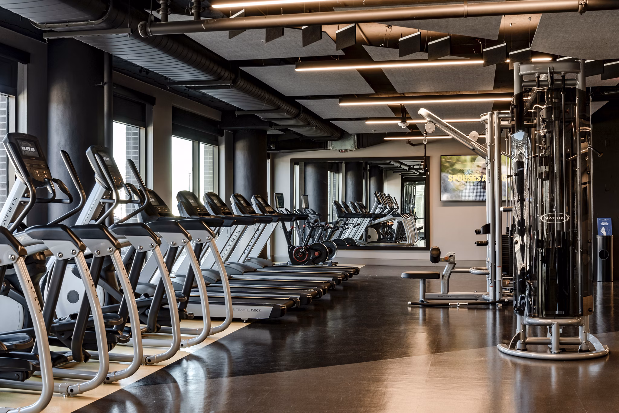 Modern gym featuring treadmills and weight machines in luxury apartments