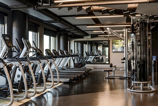 Modern gym featuring treadmills and weight machines in luxury apartments
