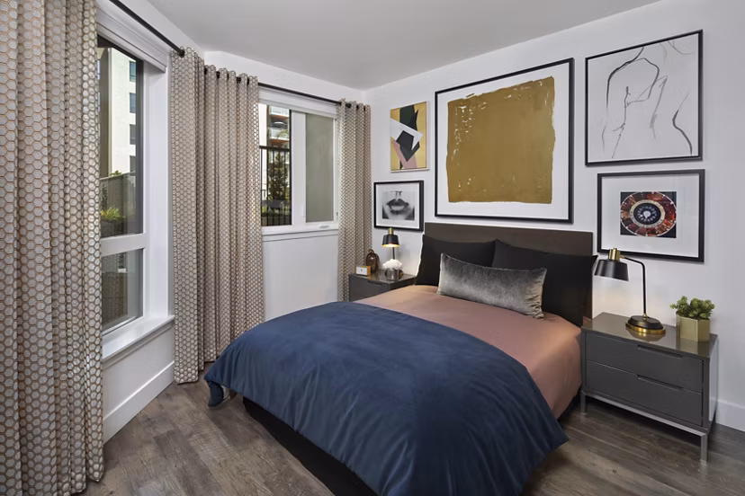 Cozy bedroom with modern decor at Lynhaven Apartments, featuring plush bedding and natural light