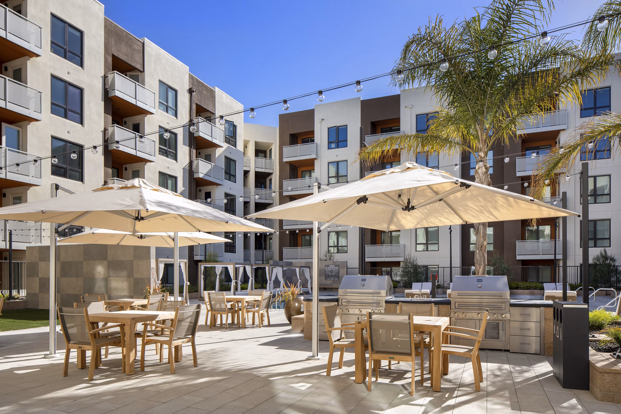 Outdoor grill area at Lynhaven Apartments with stainless steel grills and seating, perfect for entertaining in a modern community setting