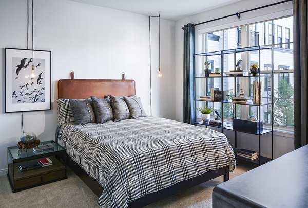 Luxurious bedroom with modern furnishings at The Atworth at Mellody Farms Apartments