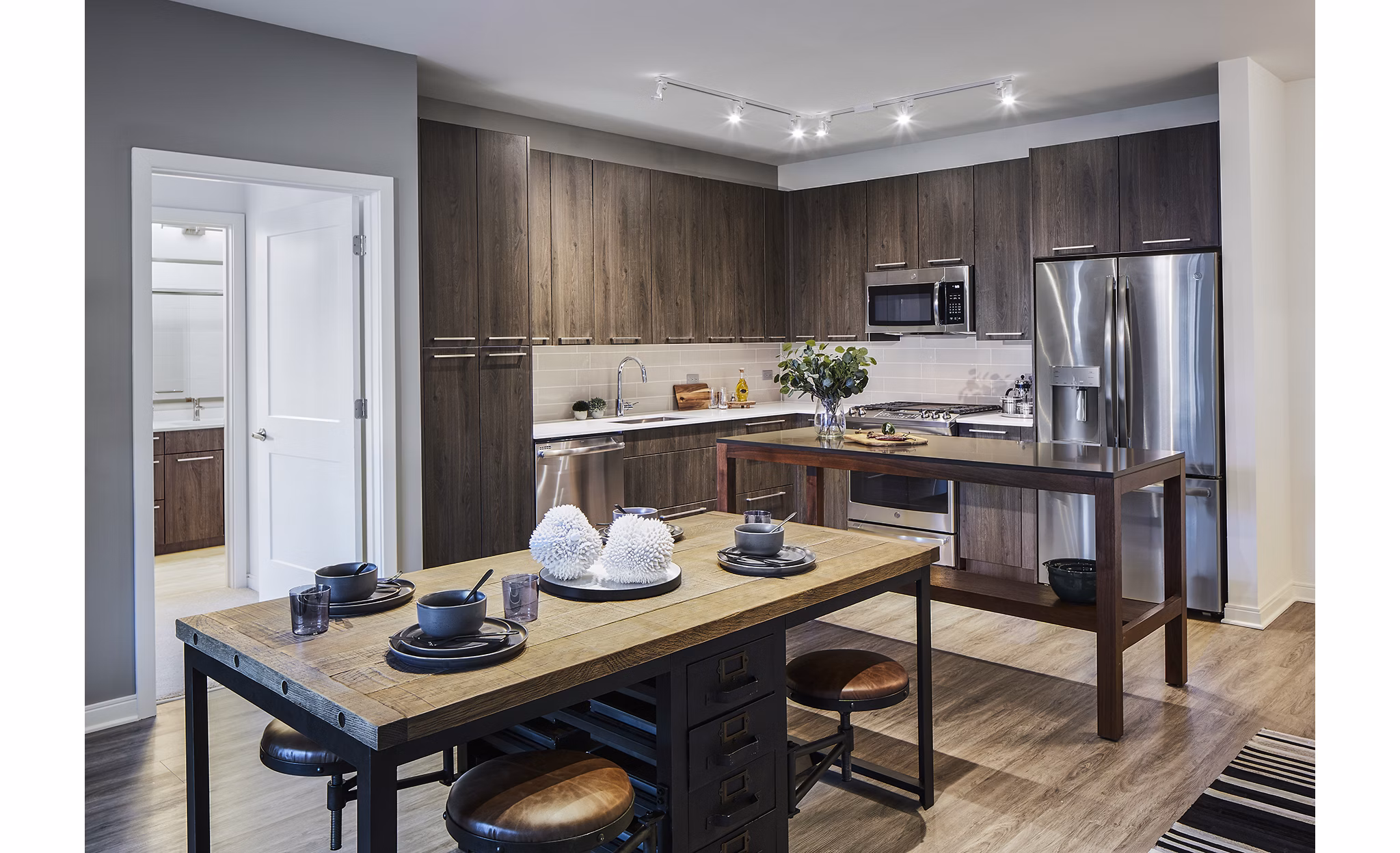 Modern kitchen with stainless steel appliances at The Atworth at Mellody Farms Apartments