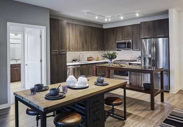 Modern kitchen with stainless steel appliances at The Atworth at Mellody Farms Apartments