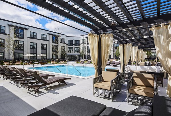 Sparkling outdoor pool with lounge chairs at The Atworth at Mellody Farms Apartments