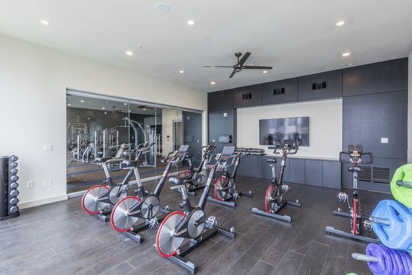 Yoga/spin studio with modern equipment at Eighteen25 Downtown Apartments, offering luxury fitness amenities in an urban setting