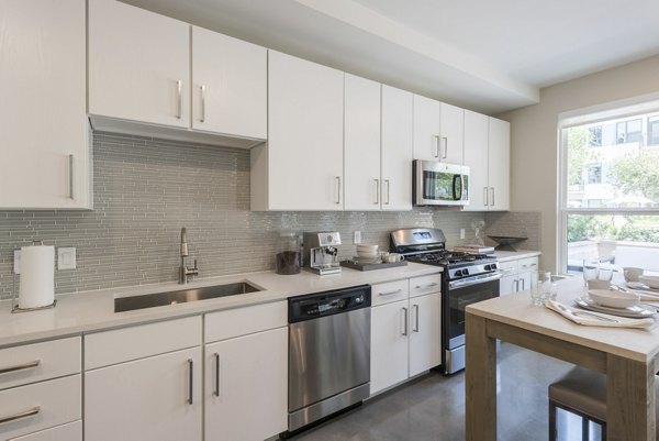 Modern kitchen with sleek cabinetry and stainless steel appliances at Eighteen25 Downtown Apartments