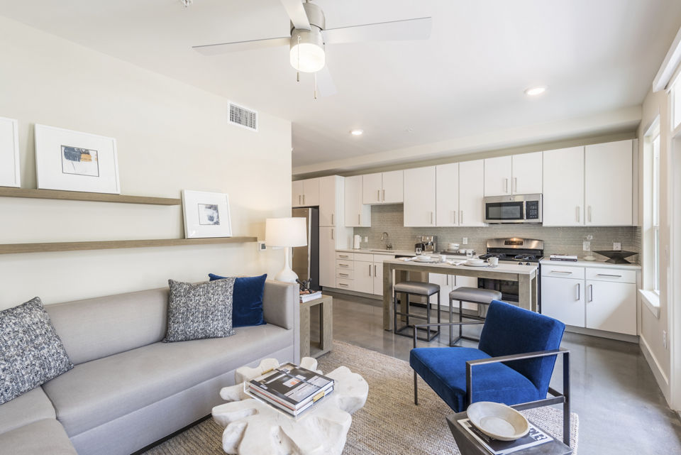 Cozy living room with modern decor and large windows in Eighteen25 Downtown Apartments, offering comfort and style in urban living spaces