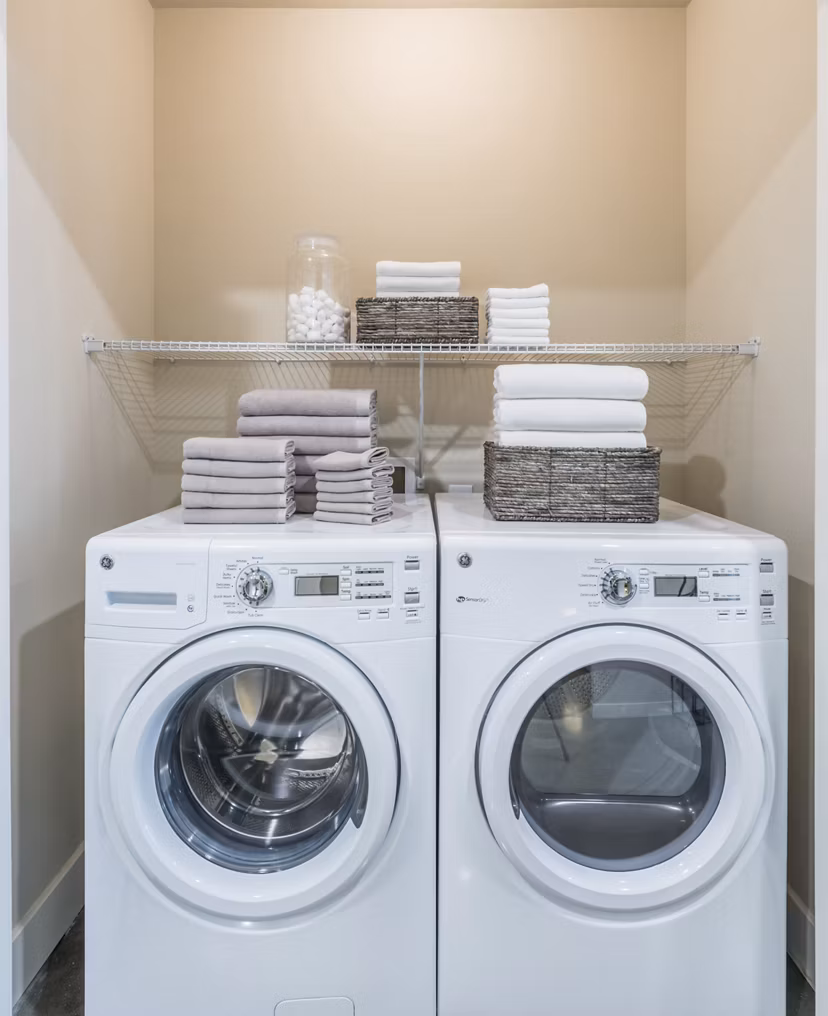 Laundry room featuring modern appliances in Eighteen25 Downtown Apartments