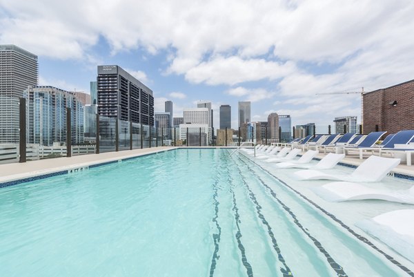 Outdoor pool with modern seating and city views at Eighteen25 Downtown Apartments