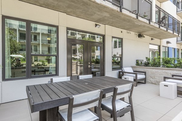 Modern outdoor patio with seating at Eighteen25 Downtown Apartments, featuring a relaxing urban ambiance