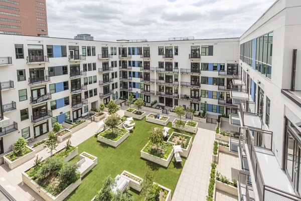 Courtyard with lush landscaping at Eighteen25 Downtown Apartments featuring modern seating areas