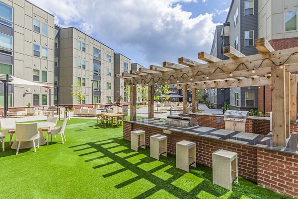 Grill area with outdoor seating at Union Blacksburg Apartments patio, perfect for social gatherings