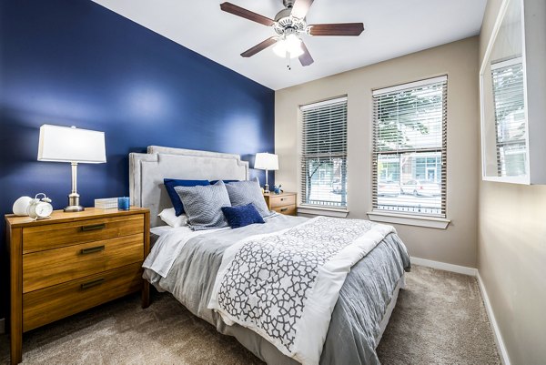 Elegant bedroom with modern decor and large windows in Whetstone Apartments