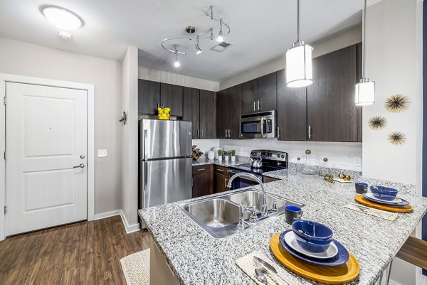 Sleek modern kitchen with stainless steel appliances at Whetstone Apartments