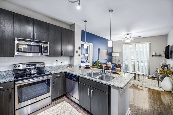 Modern kitchen with stainless steel appliances in Whetstone Apartments