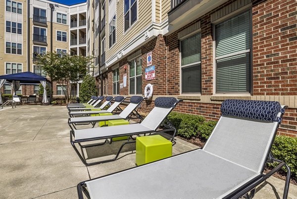 Poolside relaxation area with modern furniture at Whetstone Apartments