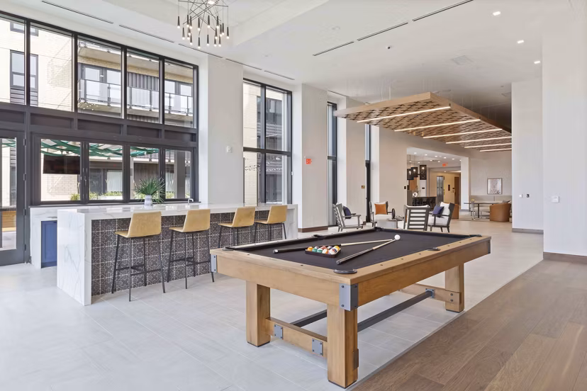 Game room with pool tables and cozy seating at The Berkman Apartments