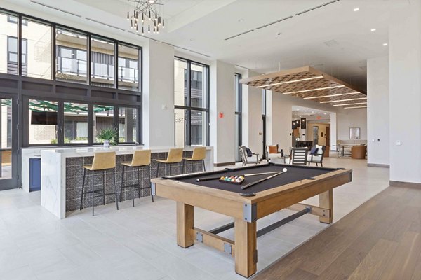 Game room with pool tables and cozy seating at The Berkman Apartments